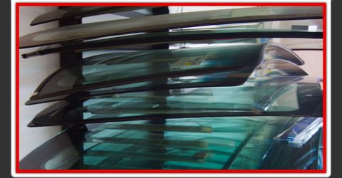 Rack of replacement windshields inside the Harvey White Auto Glass shop
